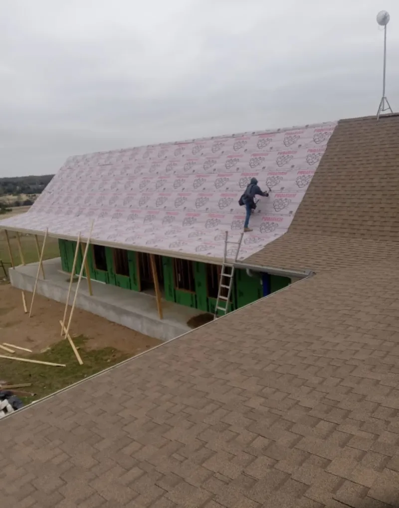 Worker preparing underlayment for a metal roof installation in Daytona Beach